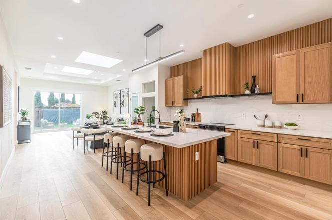 Open kitchen with oak cabinetry and island seating